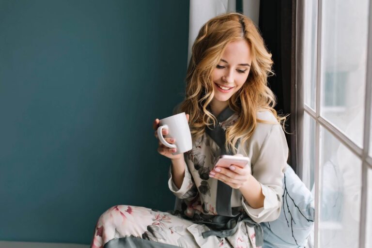 pretty-blonde-girl-sitting-window-sill-with-cup